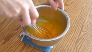 【２】卵黄に砂糖を加え、ツヤがでて少し色が薄くなるまでしっかり混ぜる。
