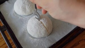 予熱が完了したら、米粉（分量外）を表面にふる。切り込みを入れ、油（分量外）を切り込みに塗る。