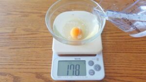 【２】卵に水（35〜38℃）を加えて溶きほぐす。