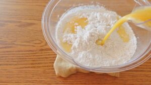【３】ボウルに米粉、塩、砂糖、イースト、サイリウムを加えて混ぜる。２を注ぐ。