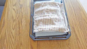 【４】ラップ濡らした布巾をかけ、35-40℃で10分発酵させる。発酵を終えたらオーブンから取りだし、250℃に予熱する。